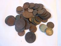 Pile of mixed old coins showing varied colors, size, and wear