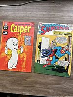 Photo of both comic books together; Casper on left, Superman on right, showing front covers and general condition.