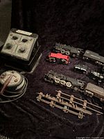 Overview of all items including 2 transformers, 2 locomotives, 2 coal tender cars marked 'American Flyer,' and several track pieces.