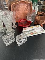 Full view showing crystal candlestick holders, crystal vases, red art glass heart bowl, ceramic cheese tray and cutter, collapsible wood basket, and wood-look plastic tray.