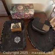 Overview of dresser top storage items including multi-tier jewelry box with intricate lid, patchwork leather shoe shine kit, wooden music box, crystal porcupine figurine, and two leather trays.