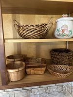 Midcentury mushroom canister and six assorted woven baskets in a wooden shelf