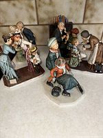 Five Norman Rockwell themed figurines arranged on a surface showing detailed period clothing and interaction scenes.