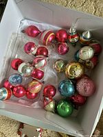 Box of assorted vintage Shiny Brite ornaments in red, pink, blue, green, gold, and silver colors, various shapes and sizes