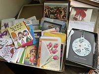 Box of assorted vintage greeting cards of different sizes and occasions, shown grouped and stacked.