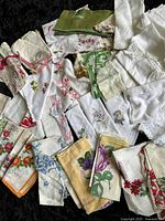 Overview of multiple vintage ladies handkerchiefs showing variety of patterns and lace details.