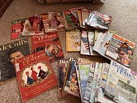 Photo showing a large spread of vintage women's magazines including Better Homes & Gardens, Family Circle, and McCall's in assorted conditions.