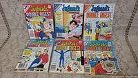 Six Jughead's Double Digest Archie comic books laid out on a beige fabric surface showing various colorful cover illustrations.