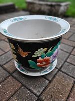 Flower pot front side showing floral and bird design on black background with wide rim