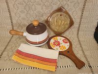 View of all 4 kitchen items together on woven cloth background.