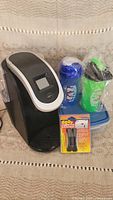 Keurig coffee maker, two Popeye’s smoothie shakers, Rubbermaid box, door guards.