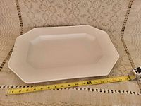 Top view of large white rectangular serving tray with measuring tape showing approximate length of 15.5 inches.