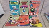 Photo of six vintage Disney comic books arranged in two rows of three, showing front covers.
