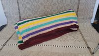 Full view of folded knit blanket showing colorful horizontal stripes.