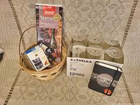 Photo showing the basket with three compartments holding a wine thermometer package and a vertical packaging, next to a box of Ikea SVALKA six wine glasses.