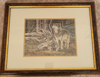 Framed wolf print showing two wolves in a forest.