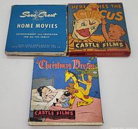 Three original 16mm film cases: Sero-Crest Home Movies (blue case), Here Comes the Circus (colorful circus themed case), A Christmas Dream (Christmas themed case) arranged side by side on a white surface.