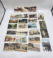 Overview of 25 antique Japanese postcards laid out showing varied scenes including temples, mountains, forests, coasts, and cultural events.