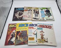 Eight vintage magazines laid out flat including National Lampoon and multiple Sick magazines.