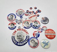 Assorted vintage U.S. political campaign buttons including candidates Barry Goldwater, Humphrey, Nixon B. Johnson, Carter, and others, showing condition and variety