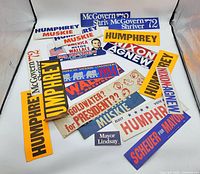 Wide shot of all vintage political campaign bumper stickers laid out, showing various candidates and vibrant colors.