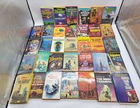 Full overview of 33 vintage science fiction paperback books arranged in 5 rows showing varied titles and authors.