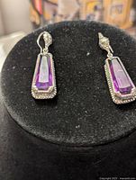 Front view of earrings showing amethyst stones set in sterling silver bezels with beaded detail.