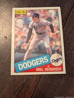Front side of 1985 O-Pee-Chee baseball card showing Dodgers pitcher Orel Hershiser in action pose.