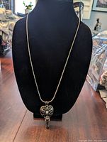 Full view of the 18-inch double chain silver tone necklace displayed on a black bust, showing the heart pendant with attached key charm.
