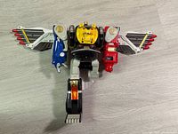 Ninja Megazord figure in standing pose showing front with lion head torso, colored limbs, and extended wings.