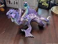 Front angle view of the purple three-headed dragon figure showing details on heads, wings, and body texture.
