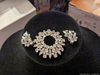 Front view of Sherman brooch and matching clip-on earrings on black display.