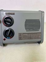 Front view of Caframo MediHeat electric heater showing control knobs, vent, and indicator light