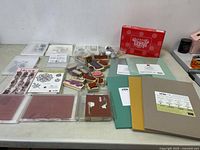 Photo showing assorted stamps, ink pads, paper pads, and Paper Pumpkin kit with crafting supplies arranged on table