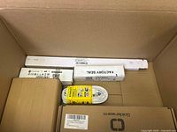 View into box showing various packed items including Stanley extension cord and factory seal kit box