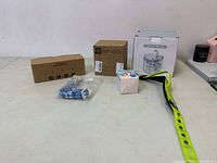 Photo showing all items in the lot including boxes of pet fountain filters, the pet water fountain, and the blue and white checkered pet collar or leash.