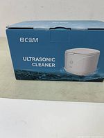 Front of box showing BCOM brand ultrasonic cleaner image and labeling
