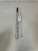Full view of Tony Dixon DX006 tin whistle with plastic case on a white surface.