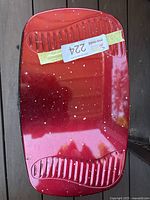 Top view of red Aerogarden unit showing glossy finish with white speckles and inventory tag taped on top.