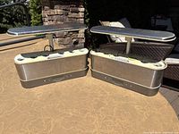 Two Aerogarden hydroponic grower units side by side on outdoor table with LED grow lights extended, showing overall condition and size