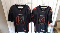 Front view of the two identical BC Lions CFL Reebok jerseys with number 14 and BC Lions logo