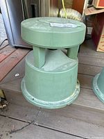 Angled view of speaker showing cylindrical multi-tiered design and base