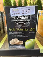 Front view of the product box showing branding, flavor, quantity (24 bisquettes), weight (14 oz / 396 g), and apple graphic