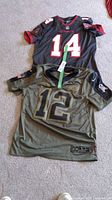Two Tampa Bay Buccaneers jerseys, numbers 12 and 14, laid flat together showing front and back.