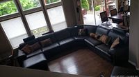 Wide overhead view of U-shaped leather sectional sofa with ottoman and throw pillows in living room