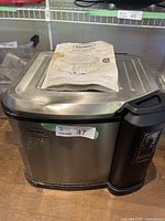Front view of Butterball electric turkey fryer with operation manual placed on top