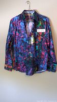 Front view of colorful Robert Graham men's dress shirt, size large, new with tags, hanging on hook against wall.