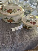 Two Royal Worcester Evesham porcelain covered casseroles displayed side by side showing fruit motifs and gold trim.
