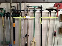 Wide view of all gardening and miscellaneous tools hanging on wall and resting on floor