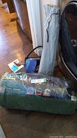 Packaged WOODS 7-person tent and other camping items on floor